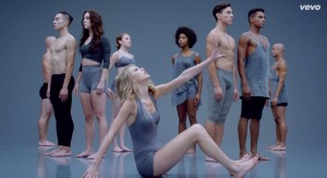 Taylor Swift reaching awkwardly in scene in music video that looks like a Gap ad.